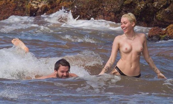 Miley Cyrus semi nua fazendo topless em praia deserta